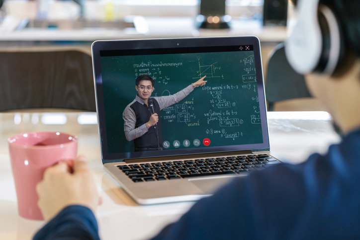 student in front of teacher providing instruction on laptop
