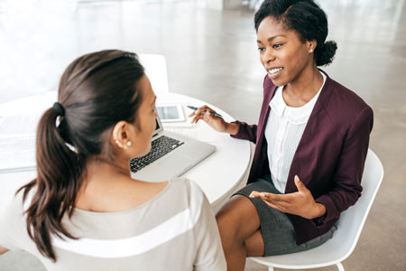 two business people seated in front of laptop