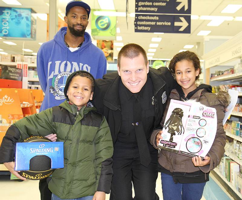 WCC officer Cameron Bauer with 7-year-old Jeremiah Vasquez (left), 10-year-old Aaliyah Bradley and Aaliyah's father, Ira Bradley, at the "Shop with a Hero" event.