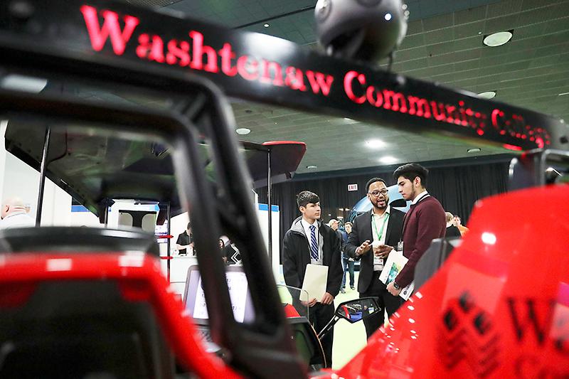 College Relations Coordinator Loren Townes (center) discusses Washtenaw Community College’s advanced manufacturing programs with visiting high school students during the Future Automotive Career Exposition event at the North American International Auto Show in Detroit on January 17. | Photo by Kelly Gampel