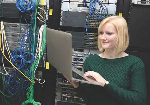 Female working on a computer in a computer server room