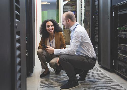 2 people working in computer server room.