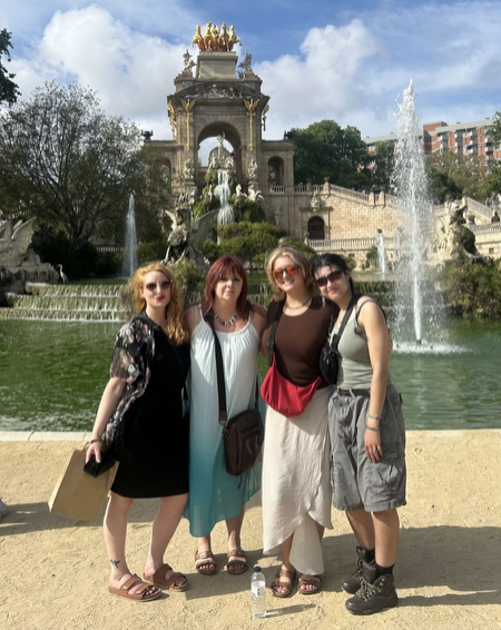 Four study abroad members pose in front of an arc in Ciutadella Park.