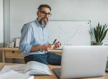 man teaching in front of laptop