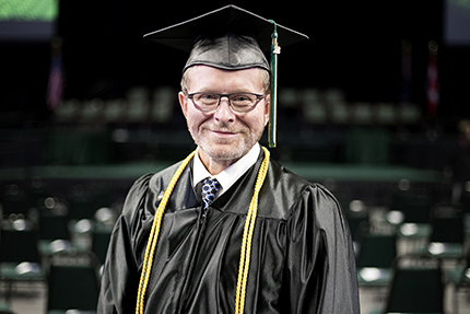 Jim Krupp, wearing the same graduation gown his wife wore 30 years ago, and each of his three children wore during their own graduation ceremonies.