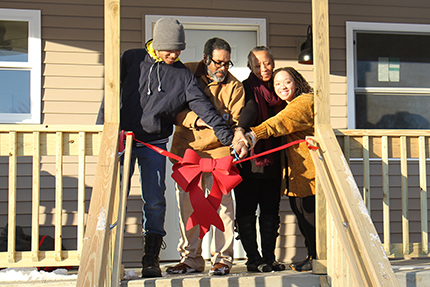 The Bond family cuts the ribbon on their new home.