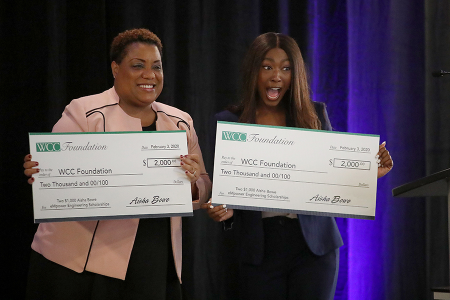 Aisha Bowe and Kim Hurns holding checks to WCC Foundation