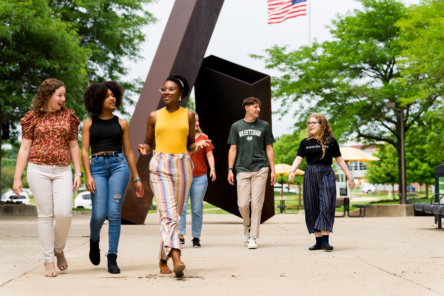 Students walking in front of sculpture