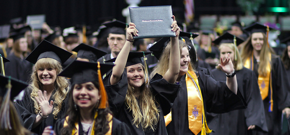 Graduate holds up diploma