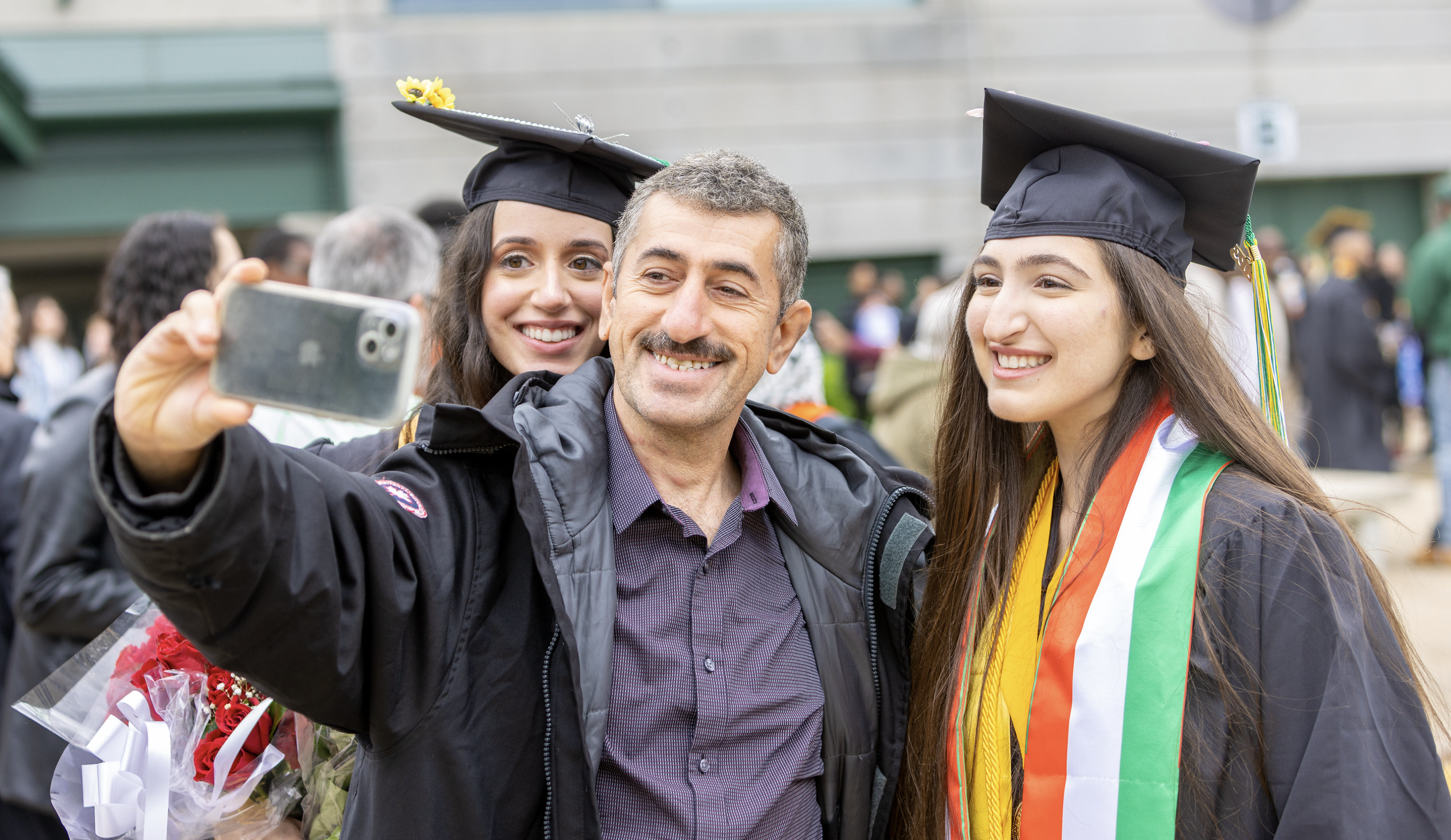 Father taking graduation photo with daughter