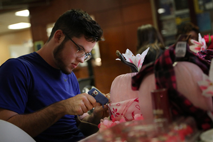 Student Chris Little attaches a bandana to a pink pumpkin Oct. 3 at a Student Resource Event raising breast cancer awareness. Little's mother has advanced stage cancer.