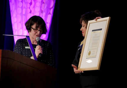 Ann Arbor City Council member Jane Lumm (left) presents Bellanca with a Community College Month proclamation from Ann Arbor mayor Christopher Taylor.