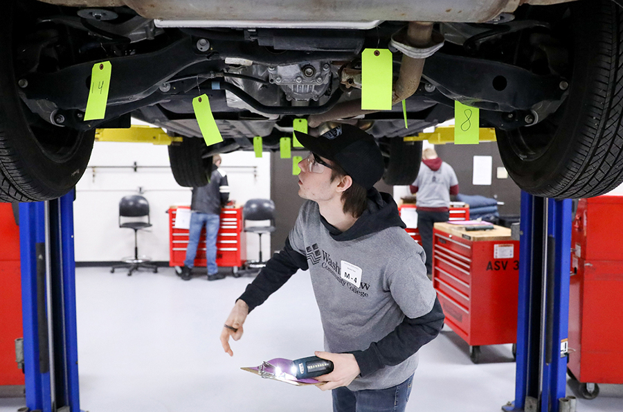 Master Technician first-place winner Liam Stanyer works beneath a car during a Skills USA competition.