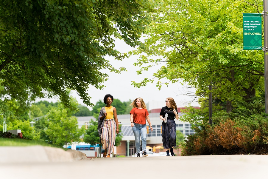 Three female students walk on campus.