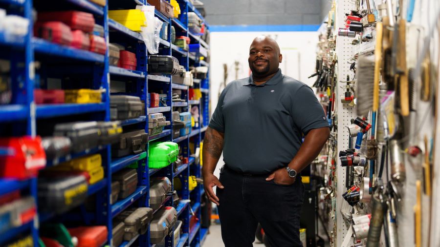 A photo of Zach Van Buren standing amidst walls of tools.