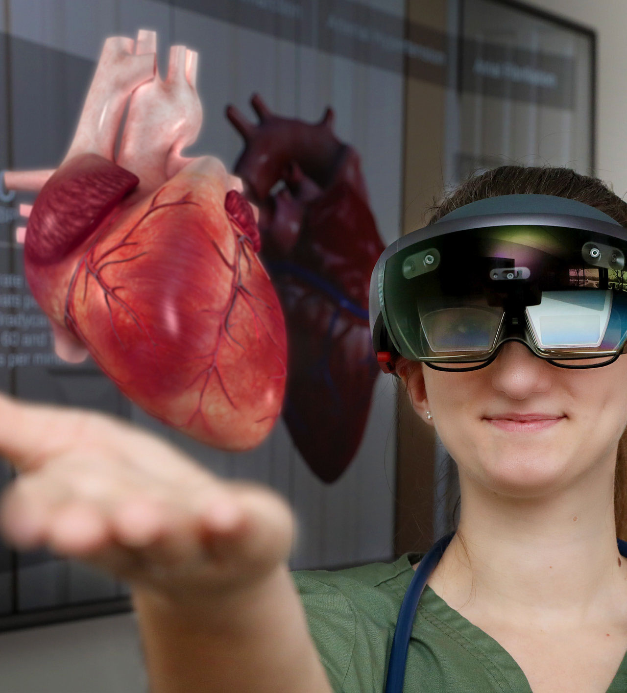 WCC nursing student Alexis LeBlanc uses a pair of Microsoft HoloLens to interact with a virtual human heart using the Insight Heart app. A one-dimensional version of what she’s seeing is displayed on the monitor behind her.
