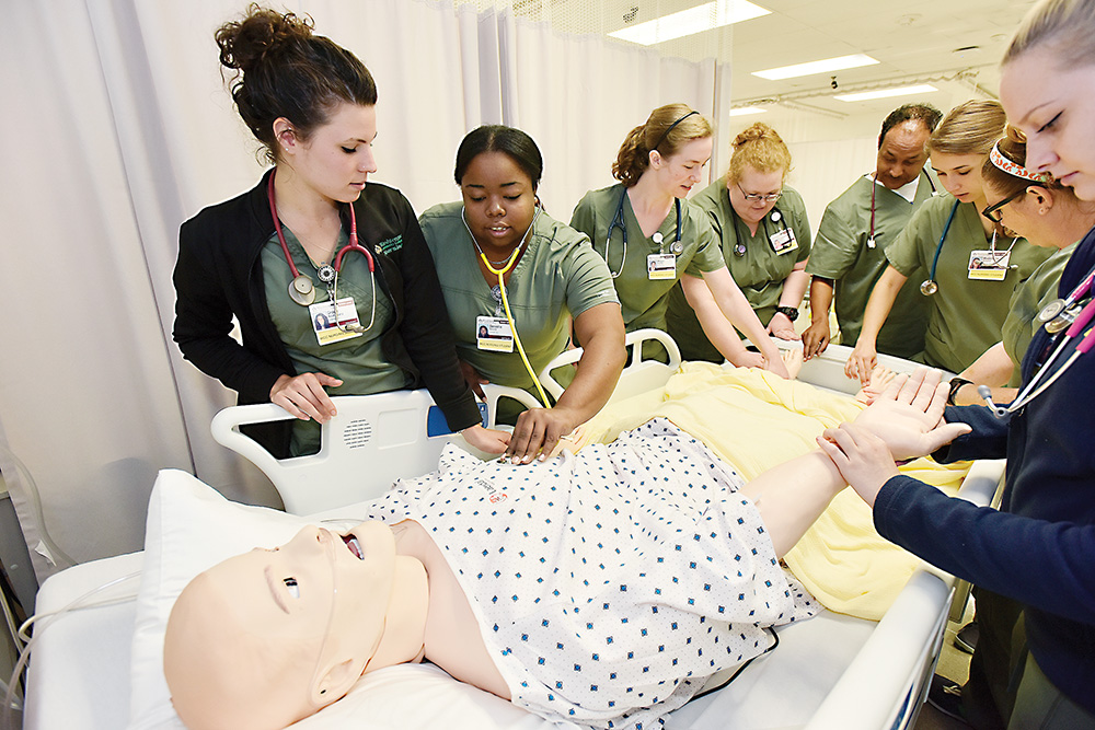 Students from a Nursing Concepts I class at Washtenaw Community College are introduced to some capabilities of the college’s new patient simulator. | Photo by Lon Horwedel Students from a Nursing Concepts I class at Washtenaw Community College are introduced to some capabilities of the college’s new patient simulator. | Photo by Lon Horwedel