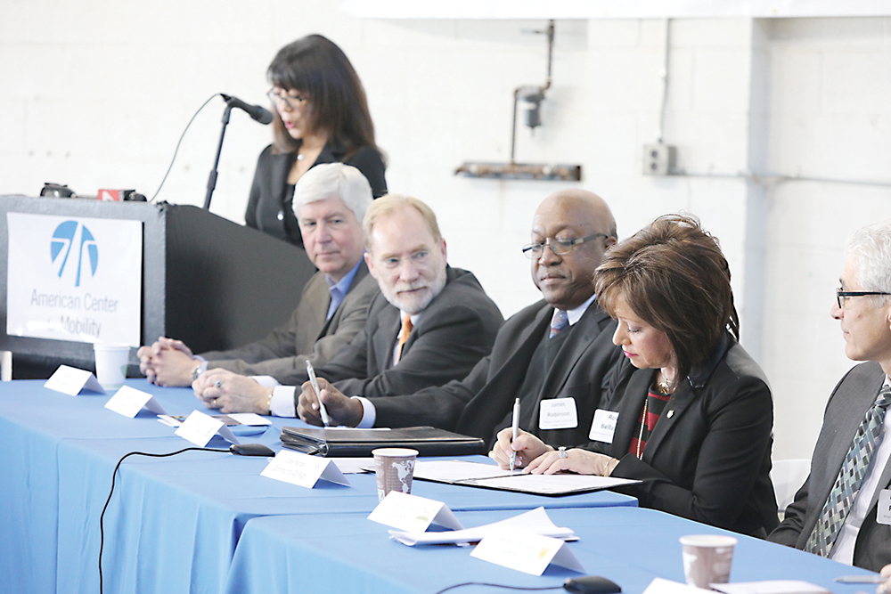 WCC President Dr. Rose B. Bellanca (right) signs the Academic Consortium agreement at the American Center for Mobility as (from left) Governor Rick Snyder, Oakland University VP David Stone and Wayne County Community College District Provost James Robinson look on. | Courtesy photo
