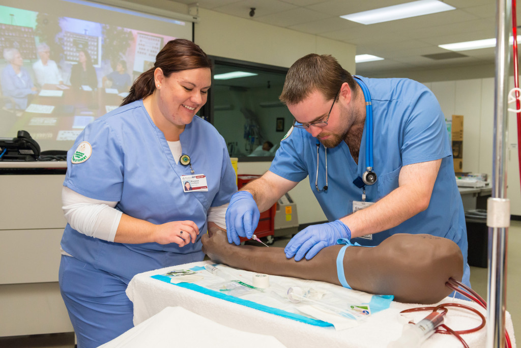WCC nursing students Maryann VanDaele and Adam Robichaud work on drawing blood from an arterial practice arm at the Sept. 2015 Free College Day event. Photo by Steve Kuzma