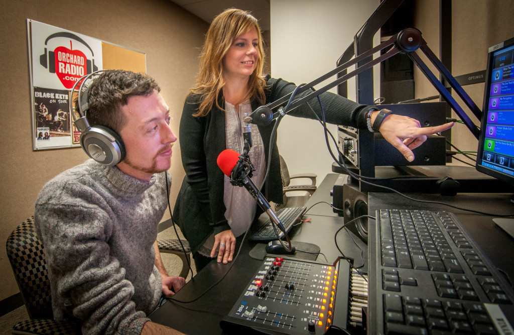 WCC Instructor/Orchard Radio Station Manager Mary Helen Ciaravino points out a playlist schedule to WCC Broadcasting Arts student Benjamin Demory. Photo by Jessica Bibbee