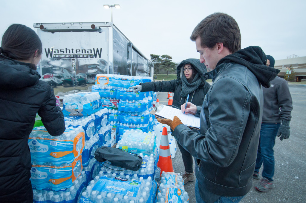 Student volunteer Mateo Piper (front right) and student workers Nina Pu (left) and Julia Selig (center) from the Student Development & Activities office organize the loading of donated water bottles.