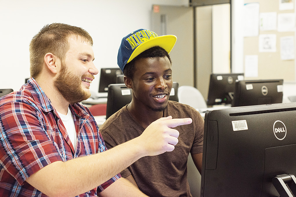 WCC graduate Marcel Henderson (left) works with Chris Young, a member of the group study session Henderson runs for new computer programming students. (Photo by CJ South)