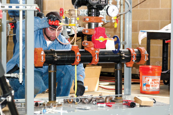 A pipefitter takes measurements during last year’s UA Instructor Training program. The group will return to campus for the 27th year on August 13-19. (Photo by Kimberly A. Borecki-Troiano)