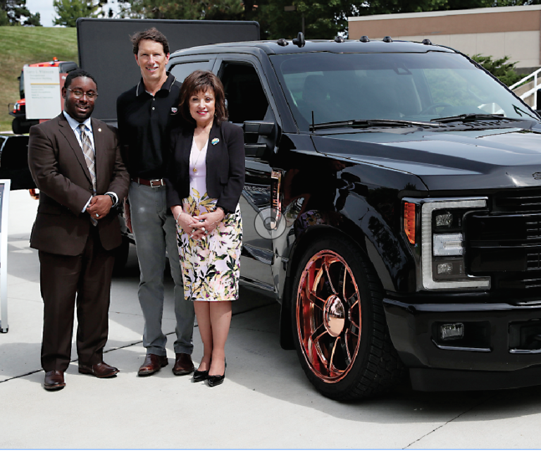 Extang Vice President of of Sales Steve Kelley (center) poses with WCC President Dr. Rose B. Bellanca and Dean of Advanced Technologies & Public Service Careers Brandon Tucker alongside the “Ultimate Tailgate Truck” that WCC students and faculty customized for the Ann Arbor-based manufacturer of truck bed accessories. 