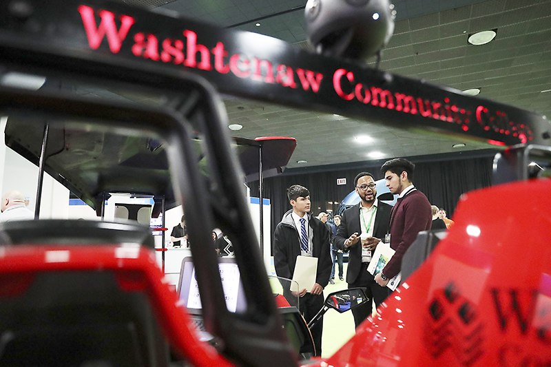 College Relations Coordinator Loren Townes (center) discusses Washtenaw Community College’s advanced manufacturing programs at North American International Auto Show