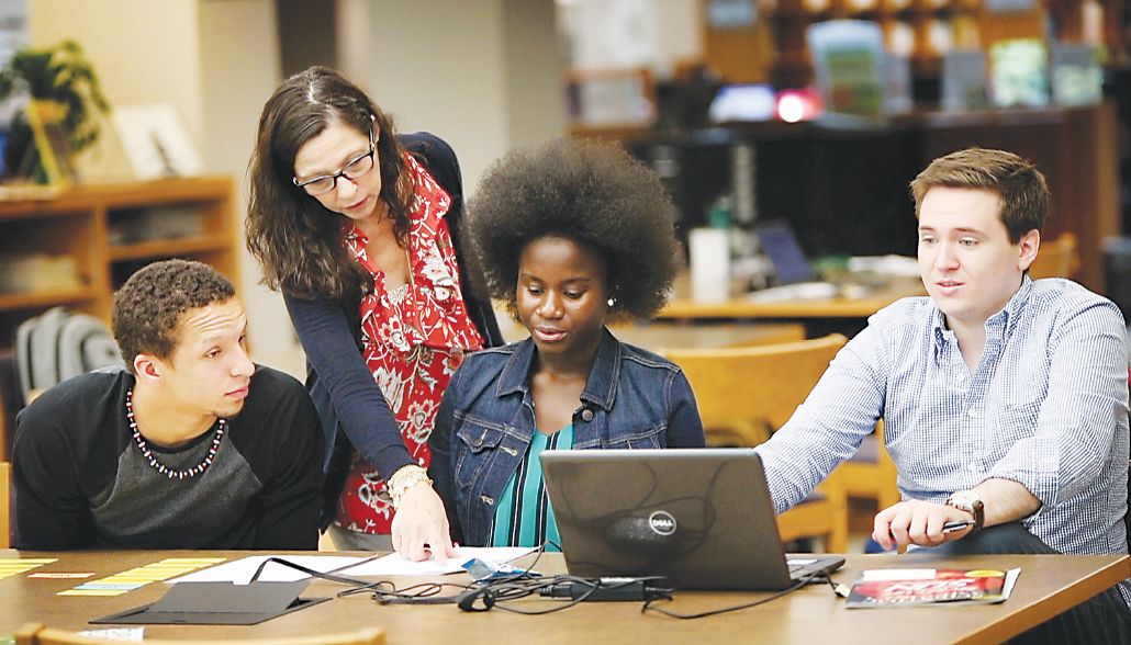 Sandy McCarthy, a librarian at Washtenaw Community College’s Bailey Library, helps STEM Scholars Program participants (from left) Emijoel Lantigua, Araba Gyan and Michael Cooke with a task during one of the program’s summer intensive sessions. | Photo by Kelly Gampel Sandy McCarthy, a librarian at Washtenaw Community College’s Bailey Library, helps STEM Scholars Program participants (from left) Emijoel Lantigua, Araba Gyan and Michael Cooke with a task during one of the program’s summer intensive sessions. | Photo by Kelly Gampel
