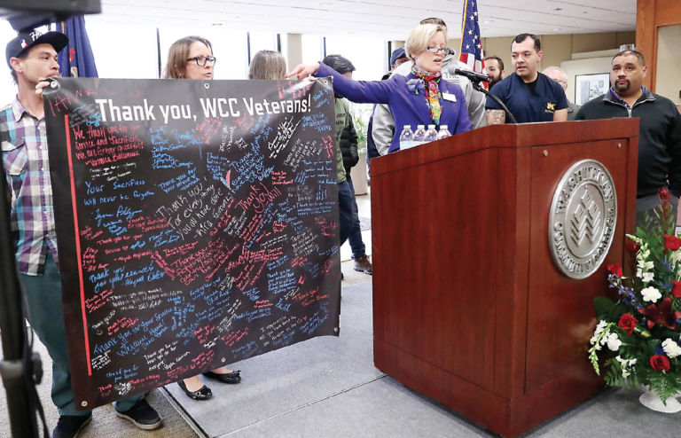 Vice President Linda Blakey presents a banner to a group of WCC student veterans during a Veterans Day ceremony on November 12. The banner, which includes notes of thanks from other students and employees of the college, is on display at the Wadhams Veterans Center. | Photo by Kelly Gampel