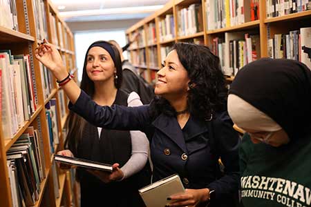 students picking out books in the library