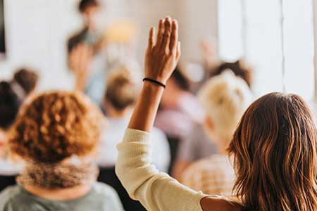 woman raising her hand in a classroom